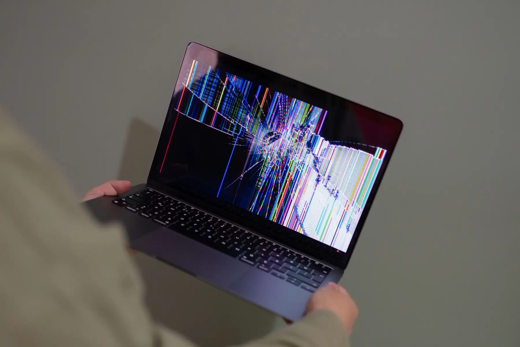 Notebook com a tela quebrada e cheia de falhas nas mãos do consumidor: troca, conserto ou dinheiro de volta pelo Código de Defesa do Consumidor