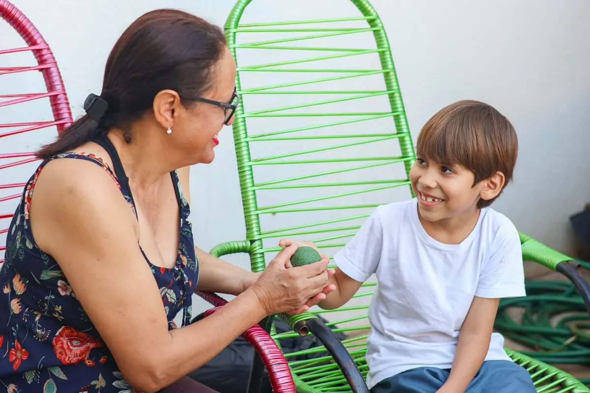 Avó e neto conversando e sorrindo ao ar livre