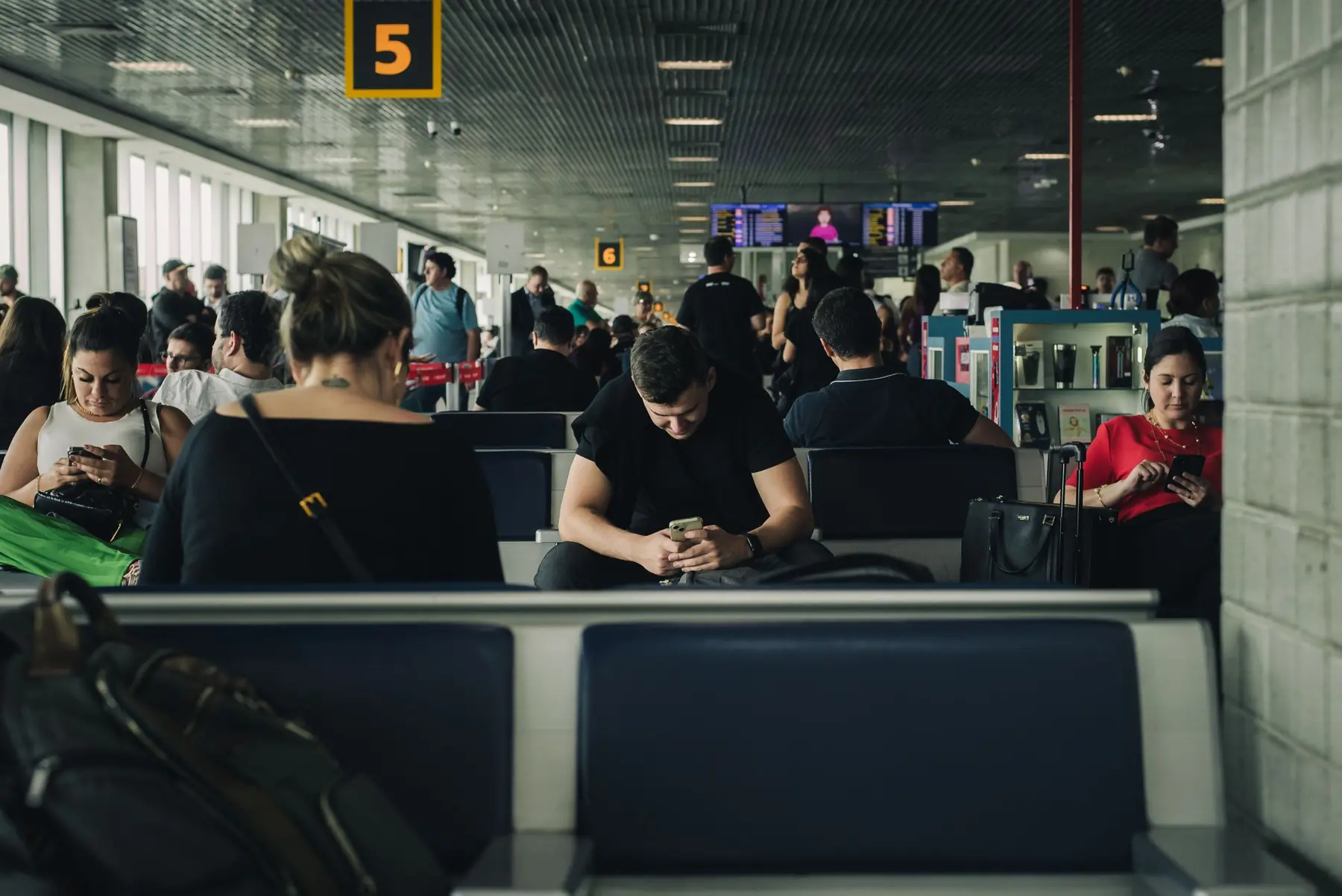 Passageiros esperando no portão de embarque do aeroporto: direitos e indenização por voo atrasado ou cancelado